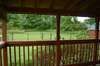 Enjoy morning coffee from this inviting covered deck with a view of this wooded area.