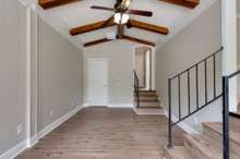 Cozy sunken den with paneled and shiplap walls, rustic beams, new LVP flooring, ceiling fan and fresh paint in the neutral and timeless color of Agreeable Gray.