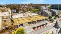 View looking back at building showing garage floor entrances and 1st floor pedestal almost complete.  Unit 305 on this front side of building looking over 16th Avenue.