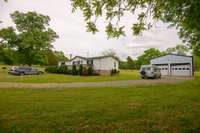 Looking from the treeline to the front of the garage and home