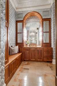 This custom vanity has a convenient sitting area, beautiful tall mirrors and plenty of space.