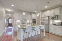 Gourmet/Luxury Kitchen with white cabinetry, granite, and built-in stainless steel appliances.