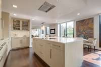 The luxury kitchen has bar seating at the huge island and abundant storage space. The recessed vent above the built-in range eliminates obstructions.