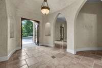 Beautiful travertine floor and arched doorways are features of the spacious entry