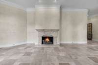 Another view of the living room with more of the custom curved walls and a gas fireplace.