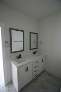 Primary bathroom with double vanity and quartz counter tops! Tile floors! Tile Shower!