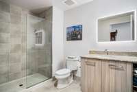 The full bathroom features granite counters, a Europen-style shower, and a backlit mirror for a spa-like start to your day