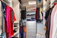 The spacious walk-in closet, thoughtfully designed by California Closets, provides ample storage for your designer wardrobe.