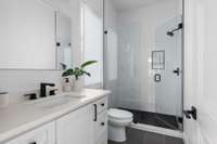 Full bathroom with vanity and walk-in shower.