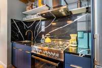 Matching quartz backsplash and counter top round out this kitchen beautifully