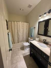 Bath tub and shower combo in 2nd bathroom.  Tile floors, 2 medicine cabinets for extra storage, new commode, bowed shower rod stays.