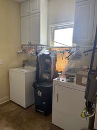 Washer/dryer can stay if written into the contract. Cabinets over both washer & dryer. Bar installed for hanging items. Sink connection exists between washer/dryer where a sink could be installed. There's a door between the kitchen and laundry room.