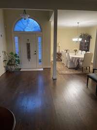 Front door with coat closet to the left and dining room to the right.  Beautiful hardwood floors and crescent-shaped transom windows.