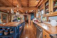 The Western Gourmet Kitchen Features a Custom 8' Wooden Island, a Huge Copper Farmhouse Sink, Custom Wood Countertops, New Subzero Fridge and Z-Line Gas Range and Microwave.