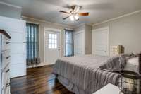 Looking into the primary bedroom on the main floor with an access door to an outside porch!