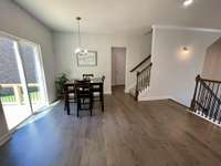 Just love the color of the hardwoods! Past the Dining space is the Primary Suite hallway, just off the Utility room... so convenient to have Laundry, Kitchen & Primary BED all on the same floor!