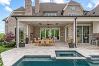 Resort-style covered outdoor living area with fireplace and outdoor kitchen overlooking fabulous Pool / Spa.