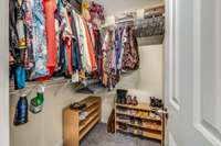 Walk-in primary closet with shelving.