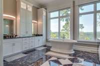 The owner's bath feels like a spa.  With an ornate stand alone tub, marble floors and crisp white cabinetry, it makes for a beautiful and ultra-functional space.