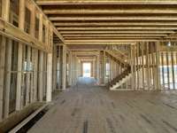 View of Entry Foyer and Switchback Staircase from Great Room  *this home is under construction  Photo taken 1/11/24