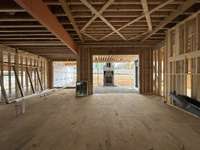 Great Room featuring a 12'ceiling with applied trim detail and a wood-burning fireplace *this home is under construction Photo taken 1/8/24