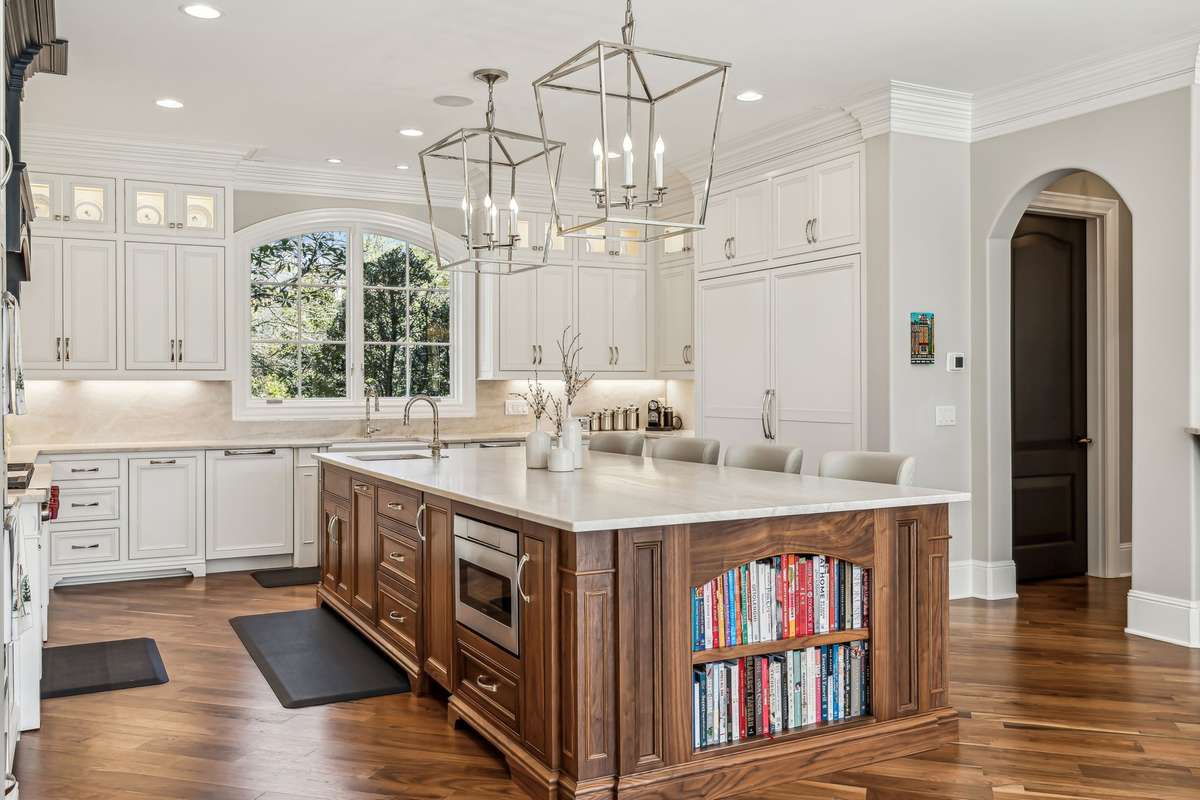 At its center, gorgeous Taj Mahal quartzite countertops with a full-height backsplash set a tone of refined luxury.