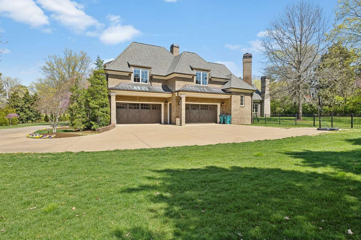 The side street driveway entrance leads to a spacious 4-car garage and a welcoming friends' entry, adding both convenience and charm.