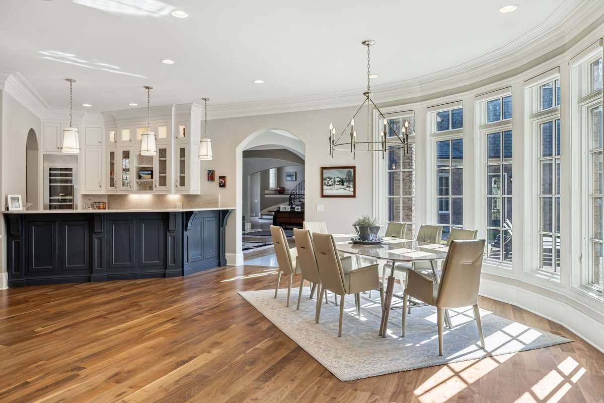 The Breakfast Room, seamlessly connected to the Kitchen, offers a bright and inviting space to start your day. Overlooking the expansive courtyard, it features a beautiful bay window with transom accents that takes advantage of the natural light.