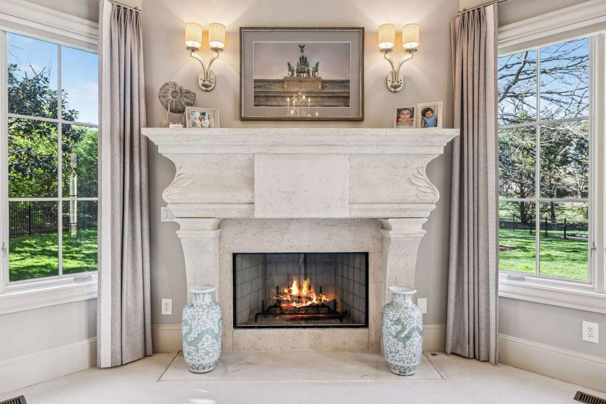 Unwind by the warm glow of the fireplace, framed in stone and accented by soft sconce lighting—the perfect setting for intimate moments or losing yourself in a favorite book.