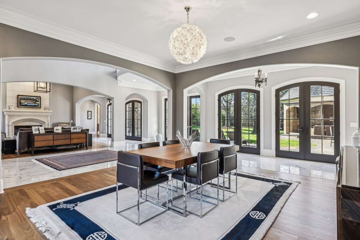 French doors offer seamless access to both the front porch and rear courtyard, creating a graceful flow for indoor-outdoor entertaining.