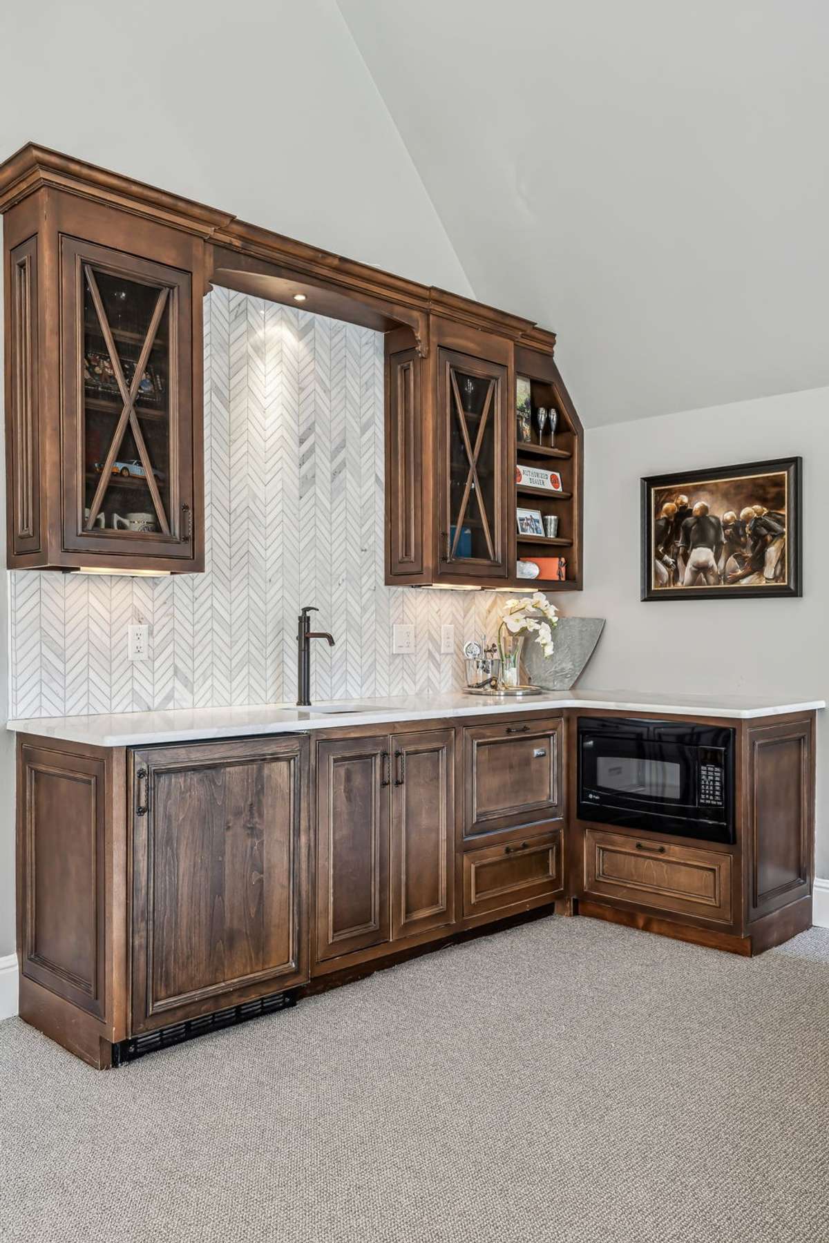 Designed with both comfort and convenience, it features a stylish wet bar with quartz countertop, copper sink, marble backsplash, built-in coffee maker, microwave, and a refrigerator with an ice maker—perfect for hosting movie nights or game days.