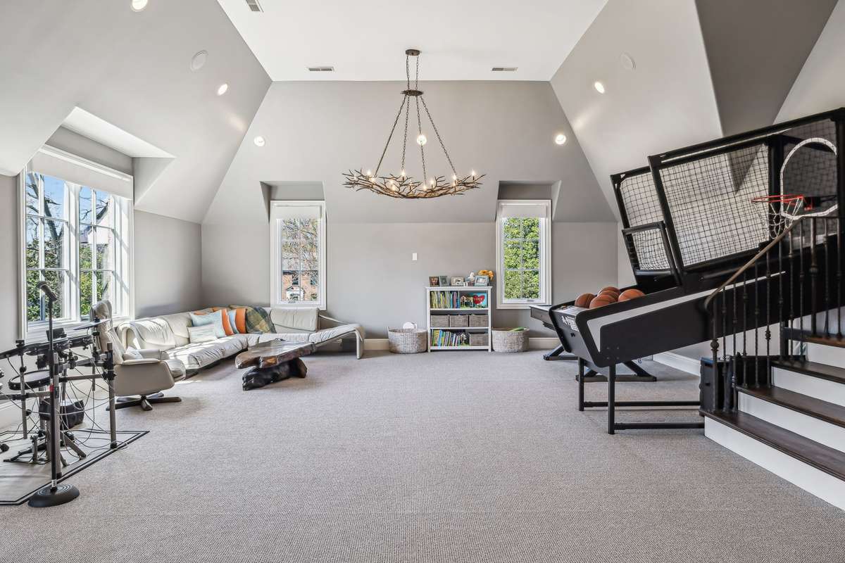 Volume ceilings enhance the spacious feel, while plush Berber carpeting adds comfort underfoot. A striking tree limb-inspired chandelier serves as a bold design statement, and a second laundry area adds functionality to this multi-purpose retreat.