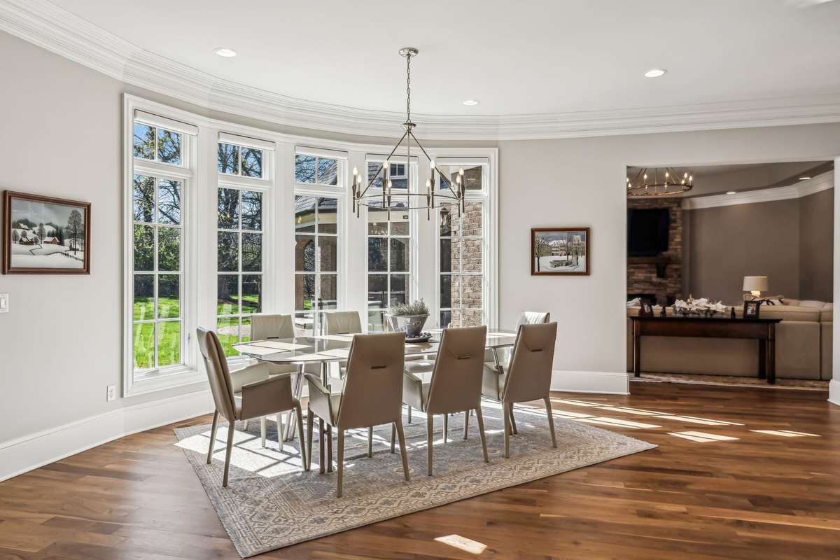 A stylish candelabra-style light fixture adds a touch of elegance, creating the perfect setting for casual meals or morning coffee in a sunlit, serene atmosphere.