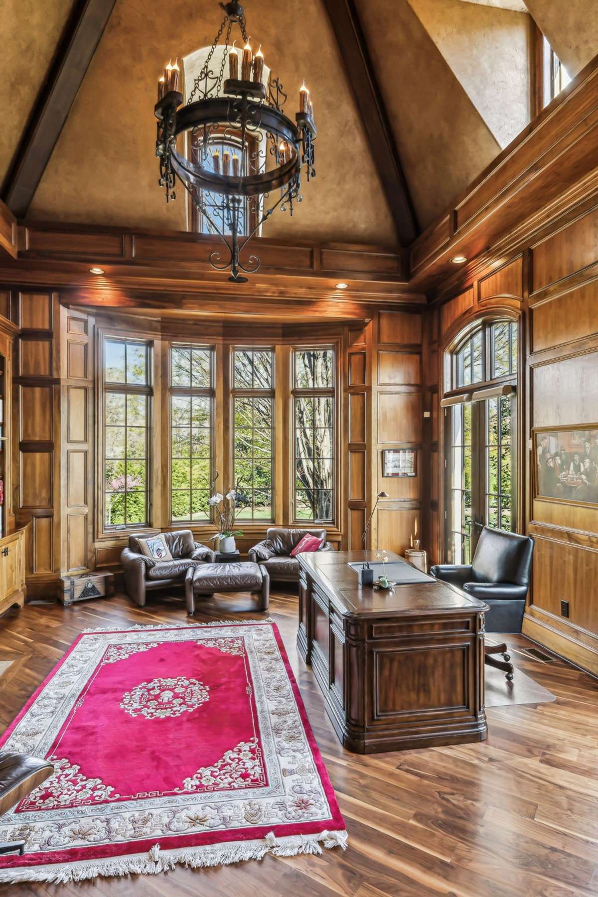 A soaring vaulted ceiling adds a sense of grandeur, accentuated by a bold, intricate iron chandelier that makes a commanding statement.