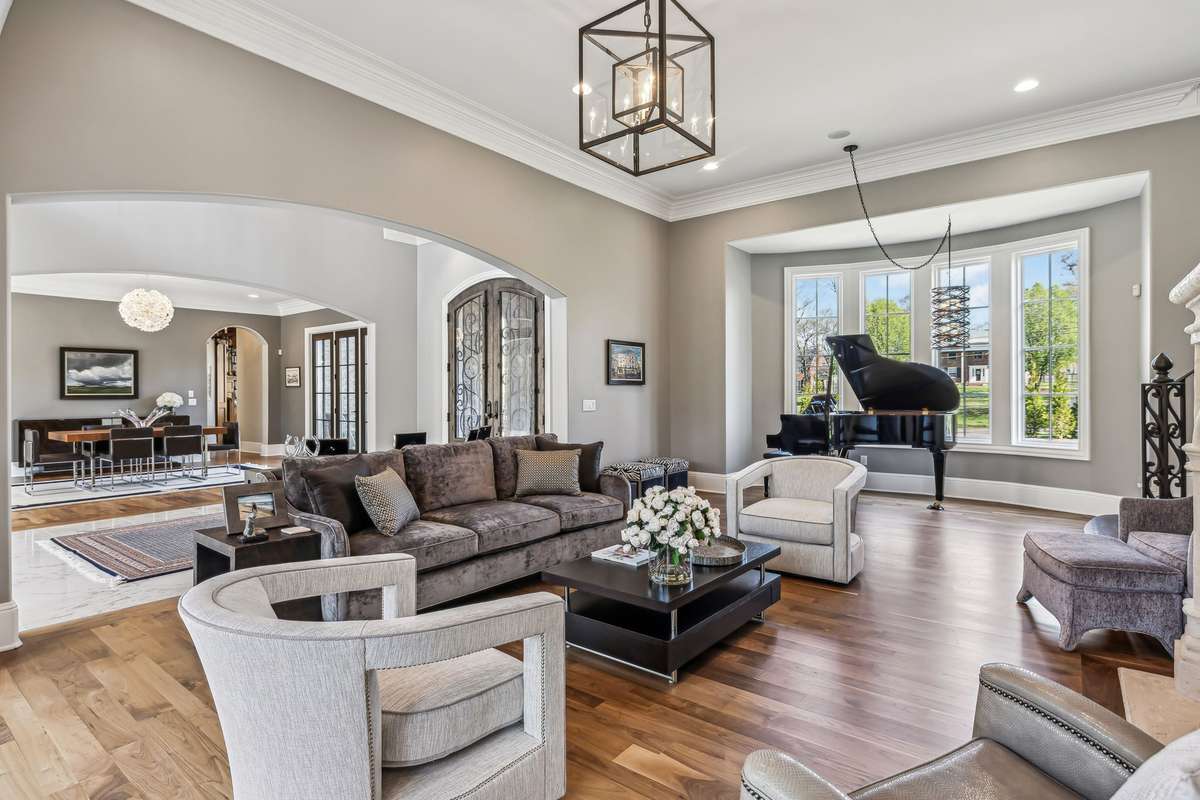 A bay of windows bathes the space in natural sunlight, while two sets of French doors open to a serene private courtyard, marrying indoor comfort and outdoor beauty.