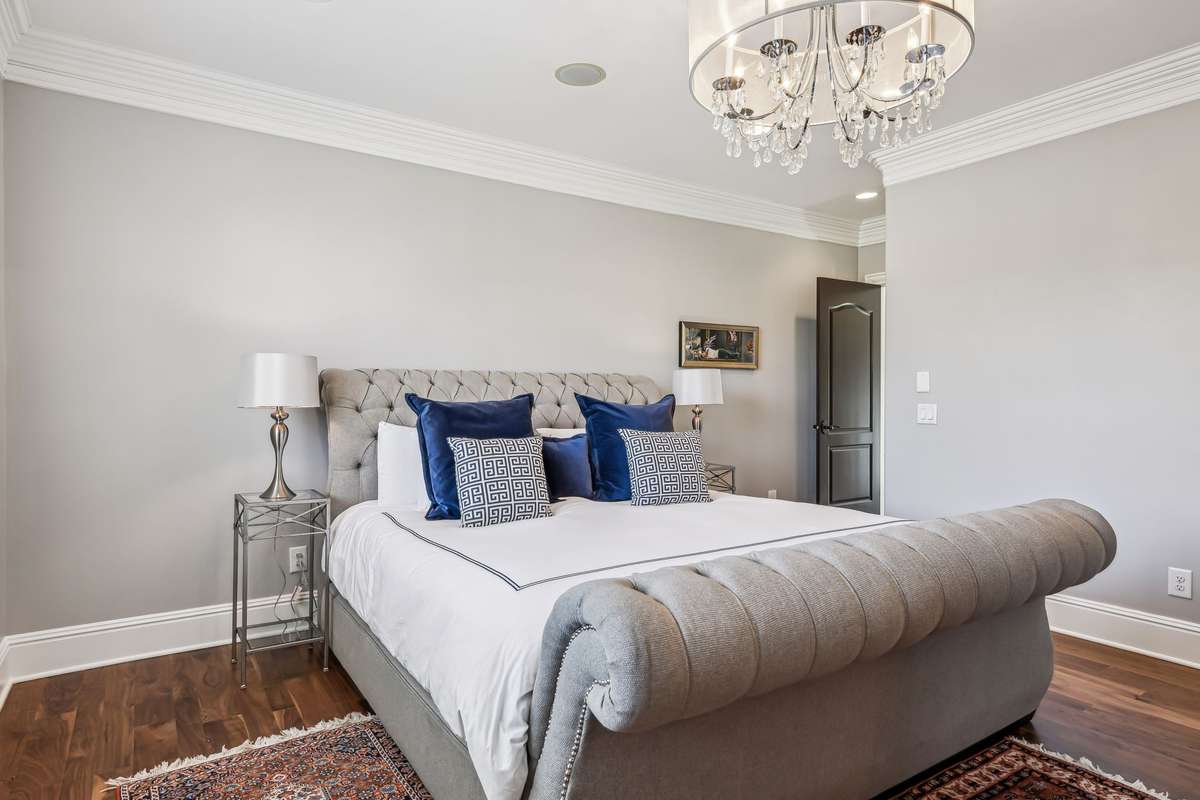The spacious Guest Bedroom features elegant plantation shutters on an arched double window for ultimate comfort.
