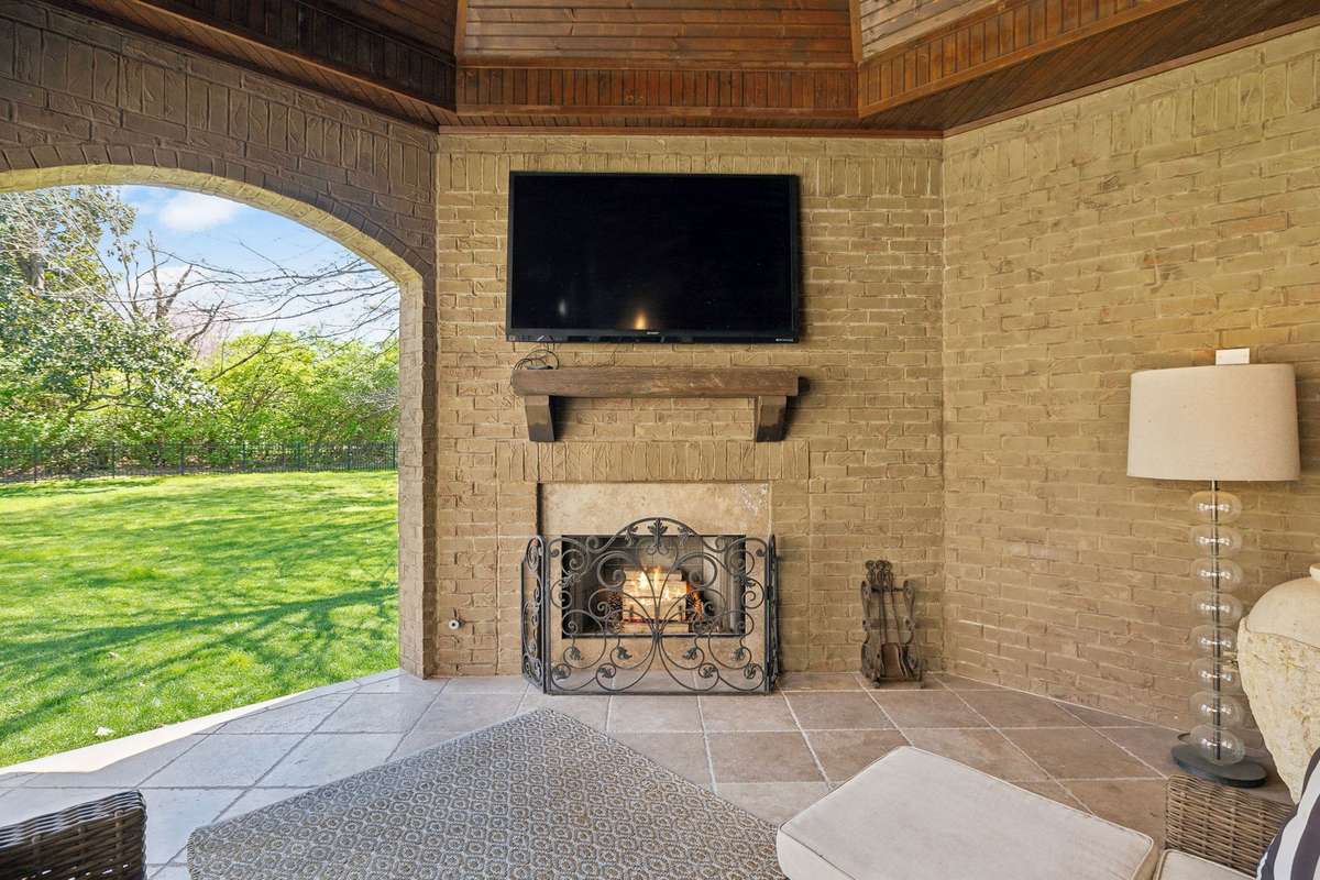 The limestone tile floor adds a touch of elegance, while a cozy fireplace with a stone surround sets the stage for intimate conversations.