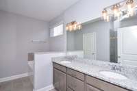 Owner's Suite with double vanities and separate tub. Similar floorplan, not actual home