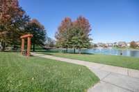 Pond with sidewalks.Walk or run, swings positioned around the Pond, and grills at one end.