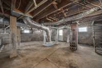 The walk-out basement/crawlspace also features a concrete floor and windows. Easy access to all your plumbing and electrical. The staircase to the right used to lead up to the utility room but was floored off years ago.