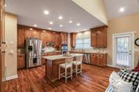 Kitchen with island and door leading out to deck making it easy to grill out