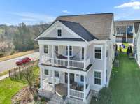 Aerial view showing both the upper balcony and covered front porch. 9556 Faulkner Square has abundant outdoor living spaces to take advantage of the open areas surrounding the house.