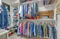 One of the 2 closets in the primary suite.  Double and single hanging along with shelving.