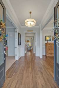 Formal entry opens to the dining room on the right and guest suite on the left.  Crown molding and wainscoting elevate your entry.  Covered front porch is a great place to unwind and enjoy the sunrise views.