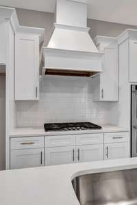 The gourmet chef's kitchen features Quartz counters, custom cabinets and vent hood, upgraded appliances and fixtures.