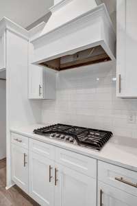 The gourmet chef's kitchen features Quartz counters, custom cabinets and vent hood, upgraded appliances and fixtures.