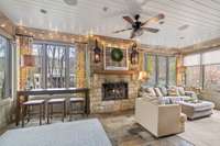 Sunroom has 2 sets of french doors from main living area & polished slate floor. Stacked stone woodburning fplace w/gas starter and wood mantel flanked by gas lanterns.  Celing fan w/light, recessed lighting & surround sound along w/treehouse views.