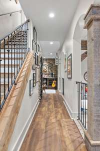 View towards wine cellar and bar/lounge section. Open railing overlooks the sitting area, seated bar and billiards area.