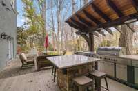 Reclaimed wood accent wall is across from the seated island. Paver patio offers seating area for outdoor dining and relaxing.