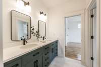 Jack and Jill bathroom with double vanities and a tile shower/bath combo.